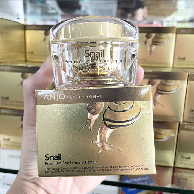 Anjo Professional Premium Snail Cream Repair 50 ml. ครีมหอยทากพรีเมียมสูตรพิเศษจากเกาหลีของแท้ ช่วยบำรุงผิวหน้าแบบถึงขีดสุด ต่อต้านริ้วรอย กระตุ้นการสร้างคอลลาเจน ช่วยให้ผิวแห้งกลับมีชีวิตชีวา เนื้อครีมมีสีขาวละมุน ลักษณะครีมกึ่งเจล มีความยืดหยุ่นจากสารสก