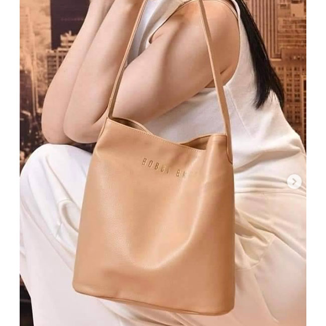 Bobbi Brown Bucket Bag กระเป๋าสินค้าพรีเมี่ยมจากช้อปบ๊อบบี้บราวน์ สีน้ำตาลครีม สีสุภาพที่เข้าได้กับทุกลุค เรียบหรู สะพายไปทำงาน ไปเรียน ไปคาเฟ่เก๋ๆได้หมด ป้ายไทย วัสดุเป็นหนัง PU กันน้ำสวยมาก จุของได้เยอะ น้ำหนักเบาสะพายสวย เรียบหรู ถือได้ สะพายได้